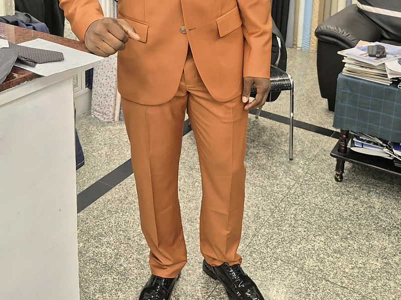 Tailored trousers in orange cloth, with the jacket above