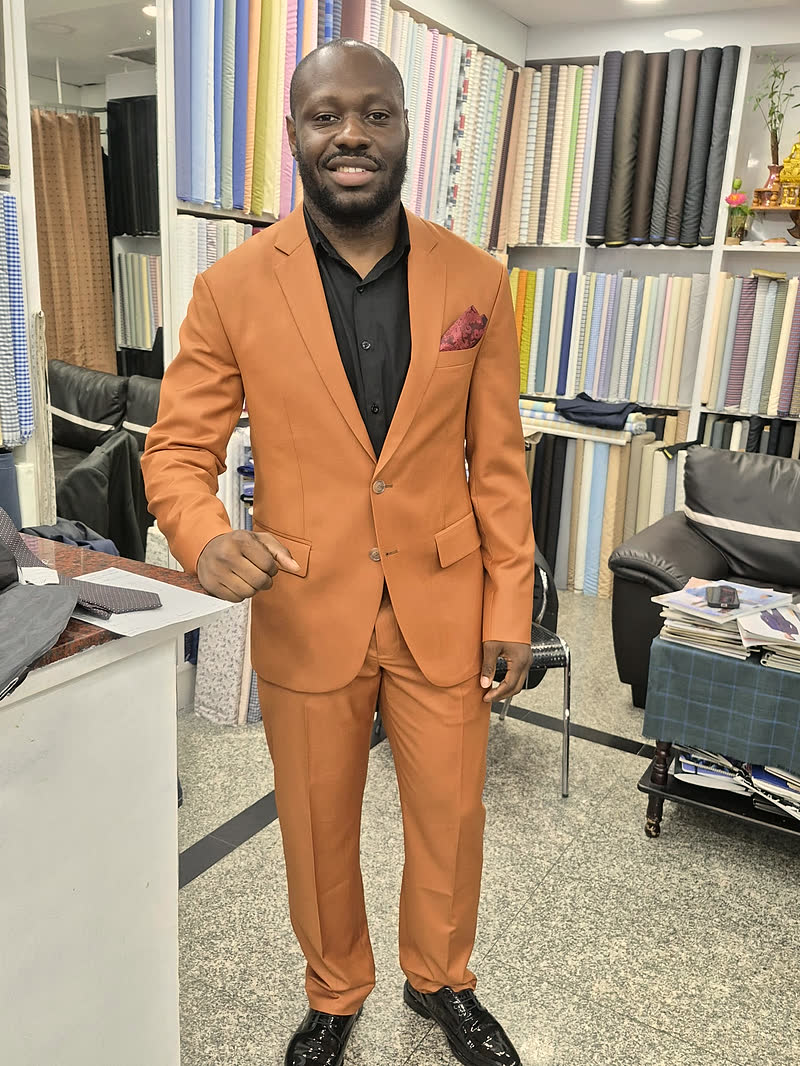 A guest in a tailored orange two-piece suit