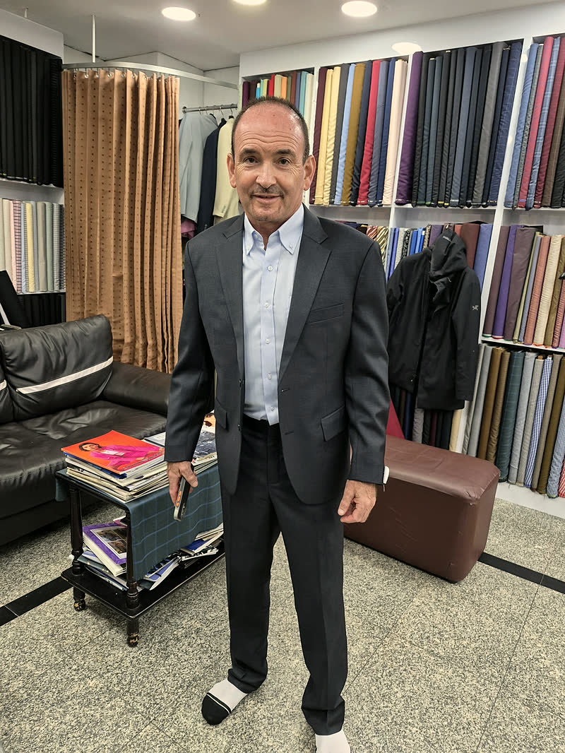 A guest in a charcoal suit with a light blue shirt