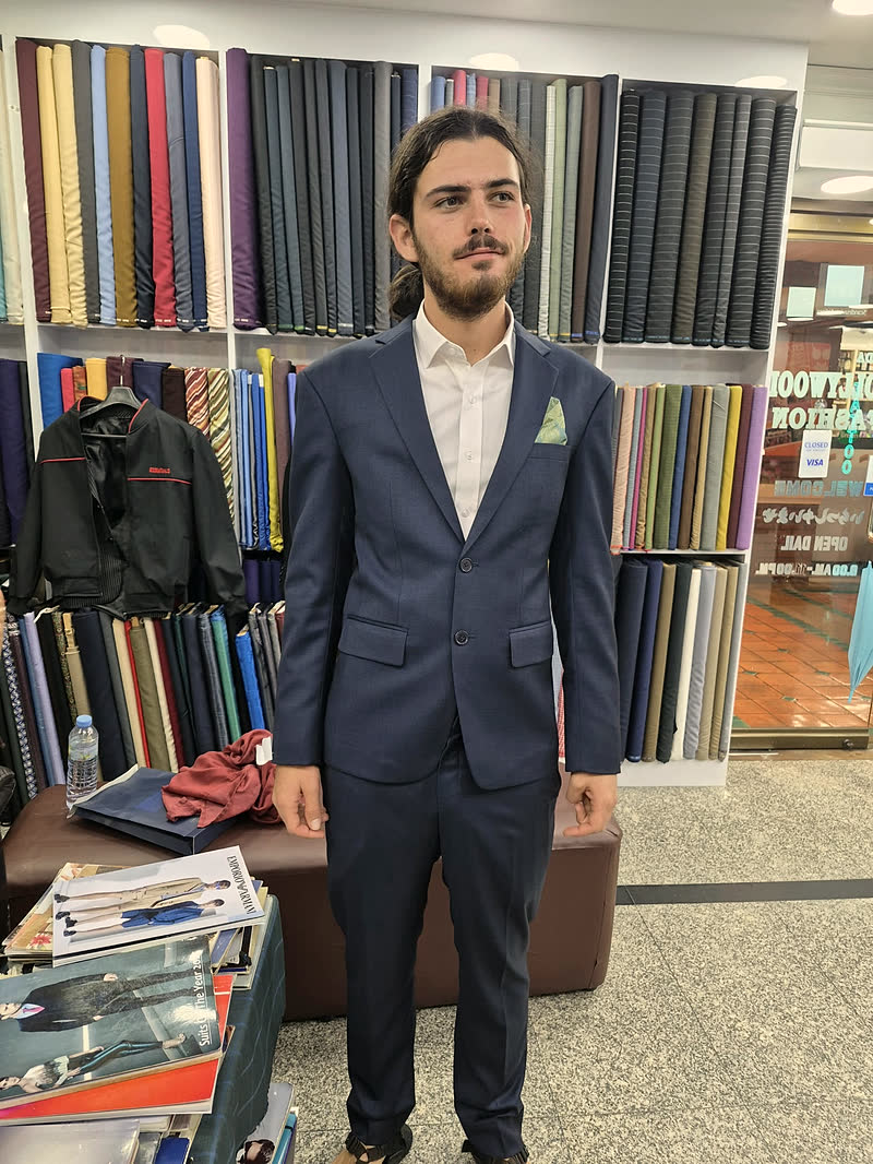 A guest in a navy two-piece suit with a pocket square