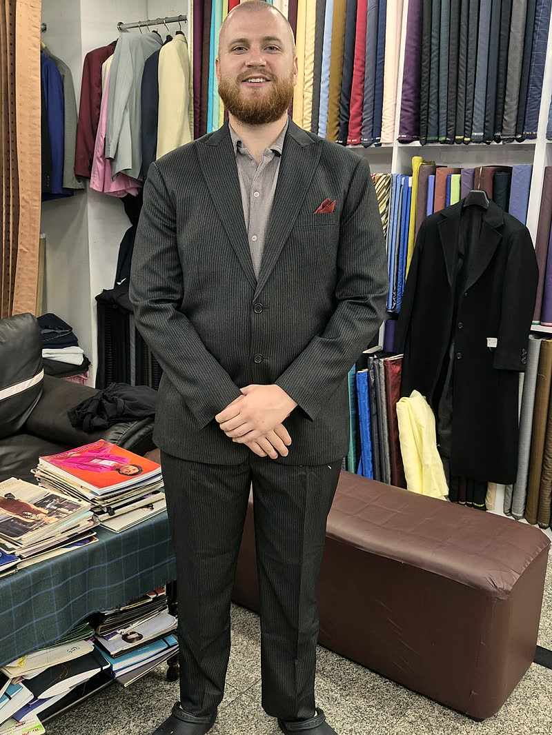 A guest in a black suit with a pocket square